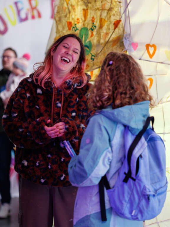 Two people laughing and talking at a creative event in Dover