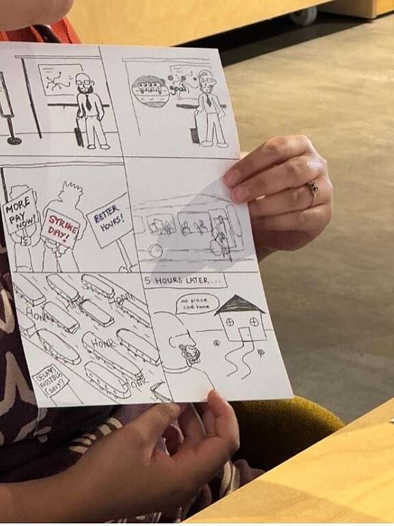 person holding paper with hand drawn cartoon