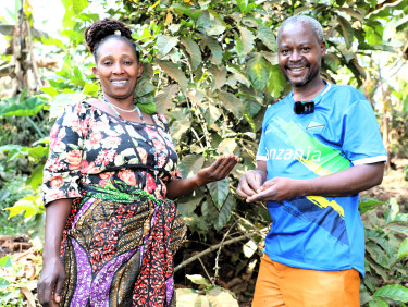 A woman and a man stand in front of a tree
