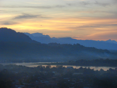 A sunset over blue forested hills