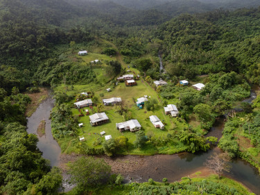 A drone shot of a small settlement in a rainforest