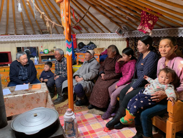 A group of people inside a traditional tent dwelling
