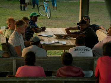 A group of people at a table looking at a pile of papers
