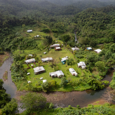 A drone shot of a small settlement in a rainforest