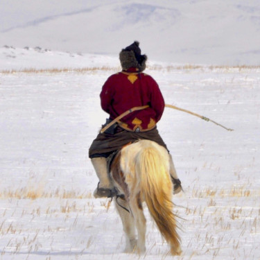 A person on a horse with a bow in a snowy landscape