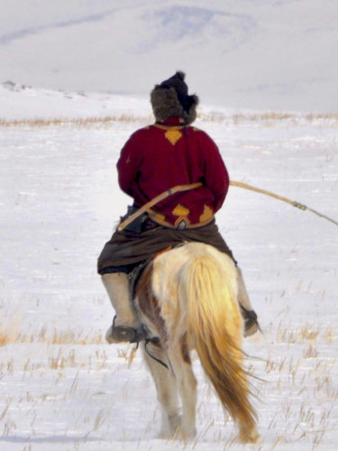A person on a horse with a bow in a snowy landscape
