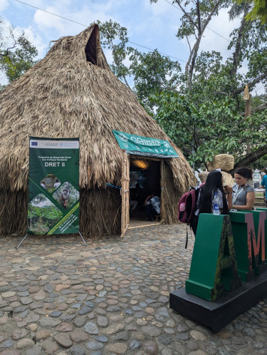 the exterior of a maloca hut with people standing outside