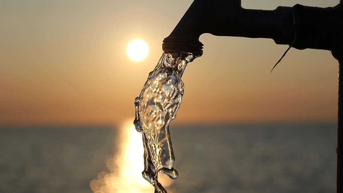 water flows from an outside tap against a sunset