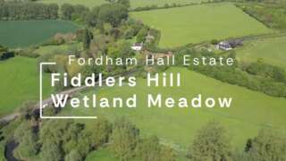 Ariel view of a landscape of fields and trees with text over the top
