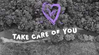 Black and white ariel view of a river running through a landscape of thick trees with a purple heart graphic and text