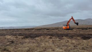 Orange digger on a peatland landscape