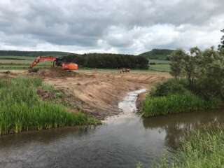 Low view of a river with a digger on the left bank