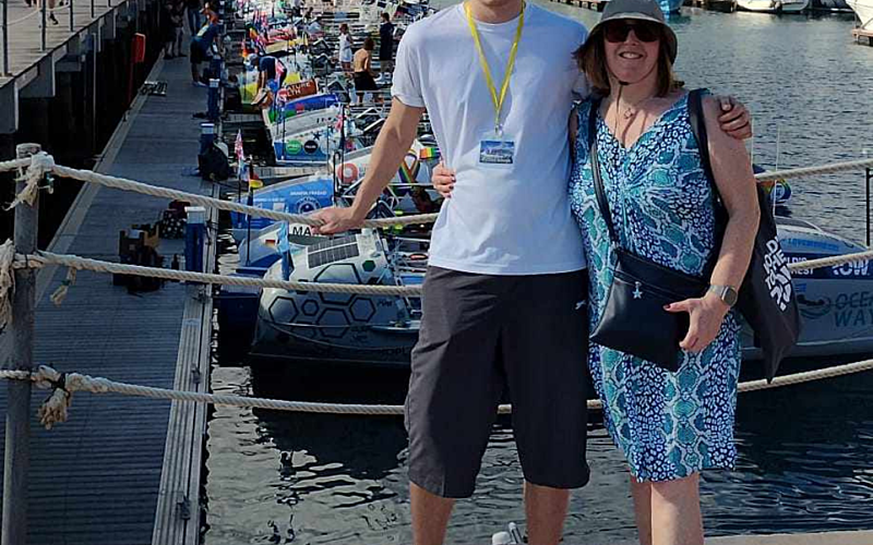Two people stood in front of a line of rowing boats