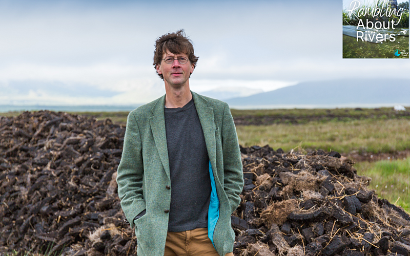 White man stood outside with grass behind him and blue sky
