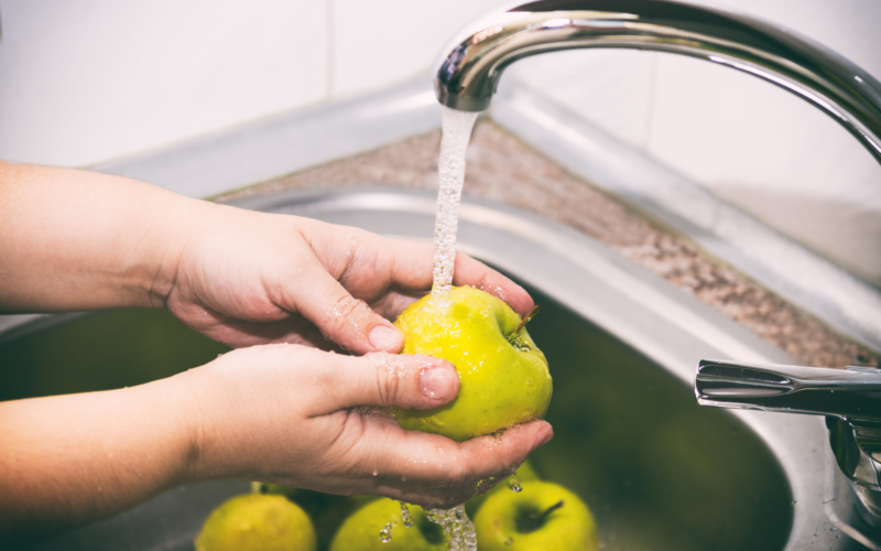 Apples being washed in the kitchen sink