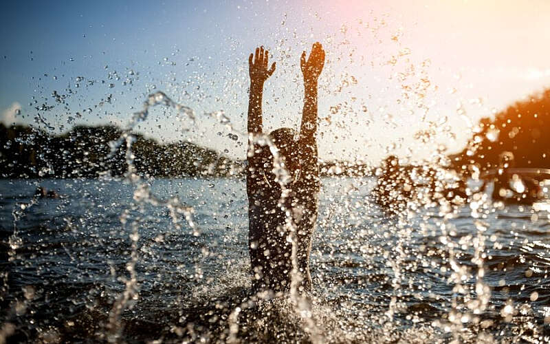 Person swimming outdoors with big splash