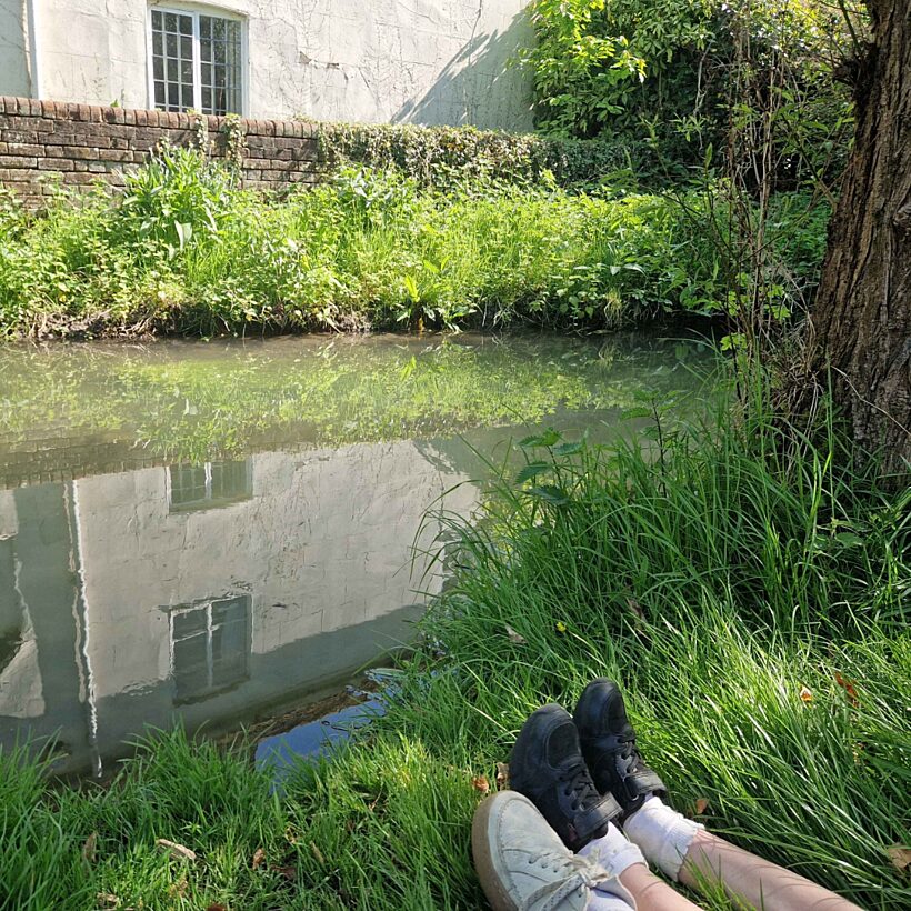 People sat with feet by the river