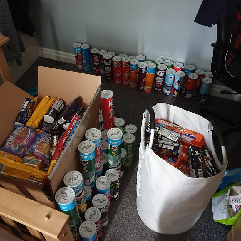 Can of food alongside boxes of food and a white bag of food