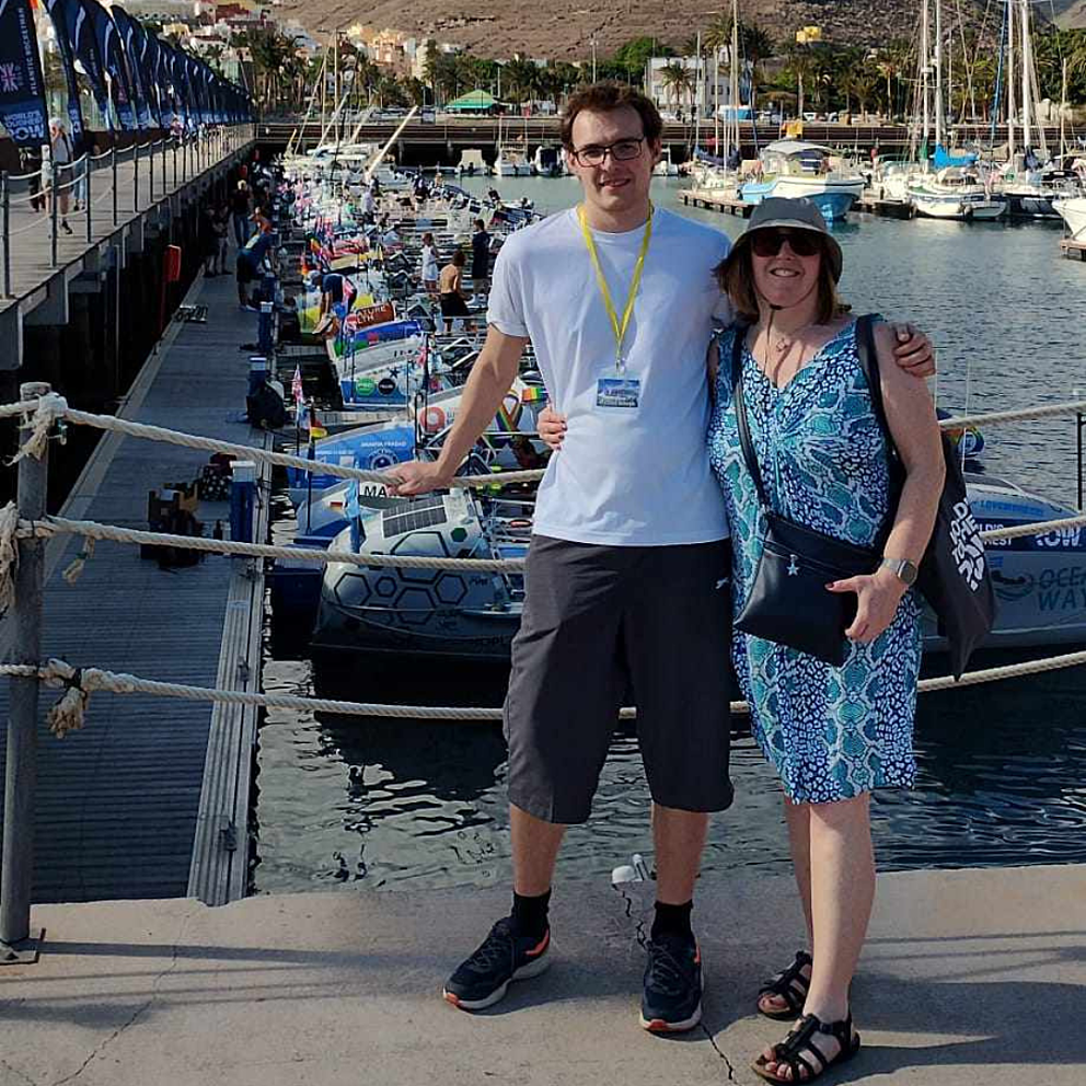 Two people stood in front of a line of rowing boats