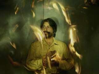 A photograph of Talvin Singh, he appears to be surrounded by fire