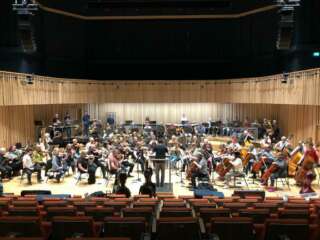 Crosby Symphony Orchestra on stage in rehearsal at The Tung Auditorium