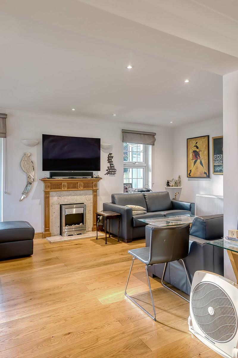 Authentic family living room with timber flooring, fireplace, neutral walls and natural light, suitable for contemporary domestic filming.