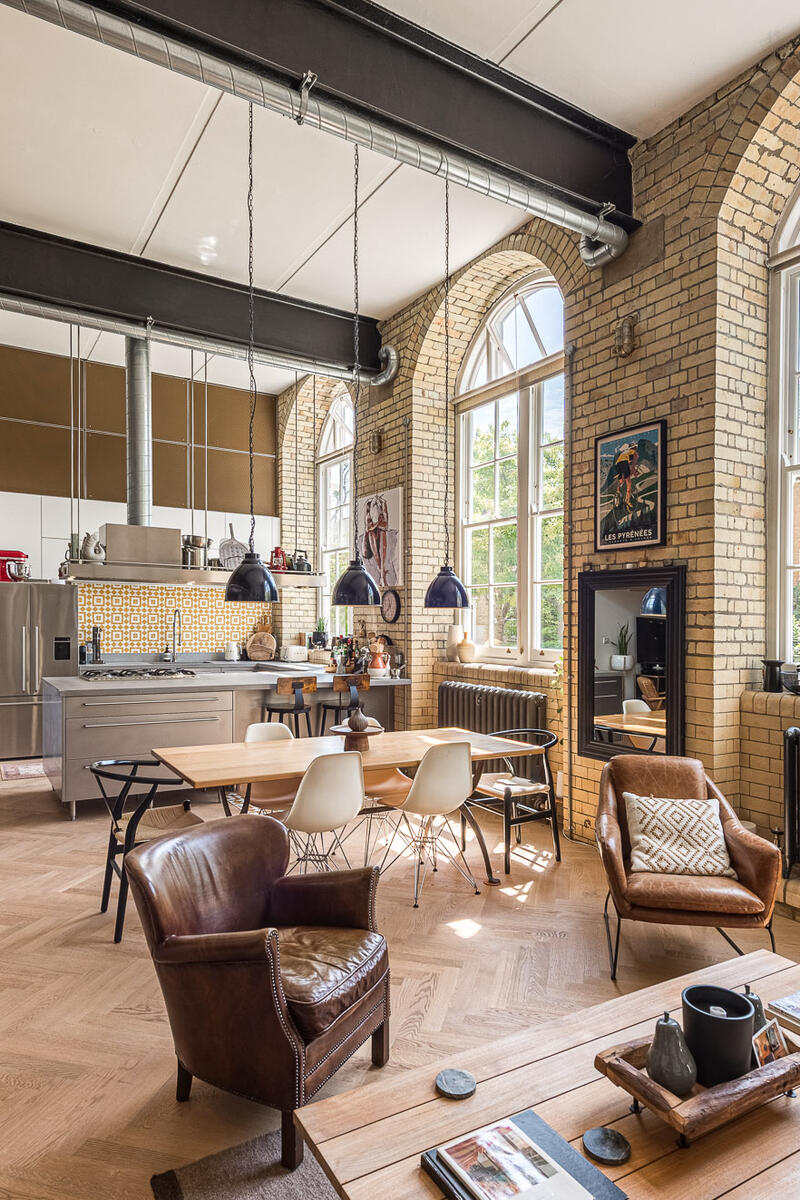 open-plan-living-space-film-location.jpg Open plan living space in a converted Victorian school with double-height ceilings, exposed brick walls, arched windows and industrial interiors.