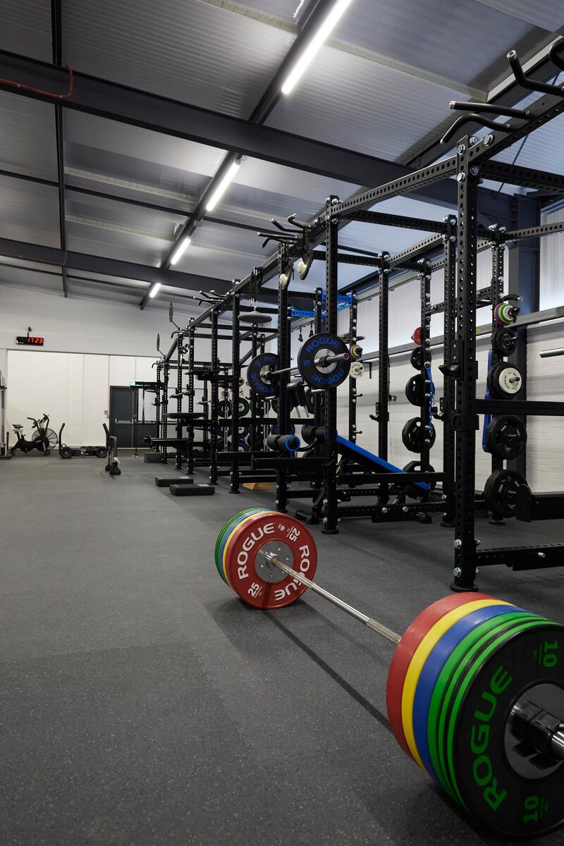 Open-plan warehouse-style strength and conditioning facility with premium gym equipment, high ceilings and industrial interiors in Winchester.