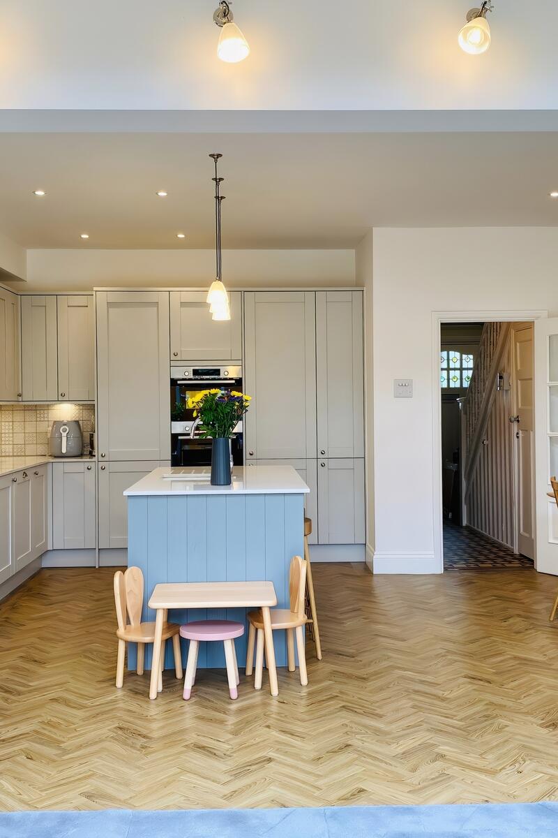 Open-plan family kitchen with island and herringbone flooring