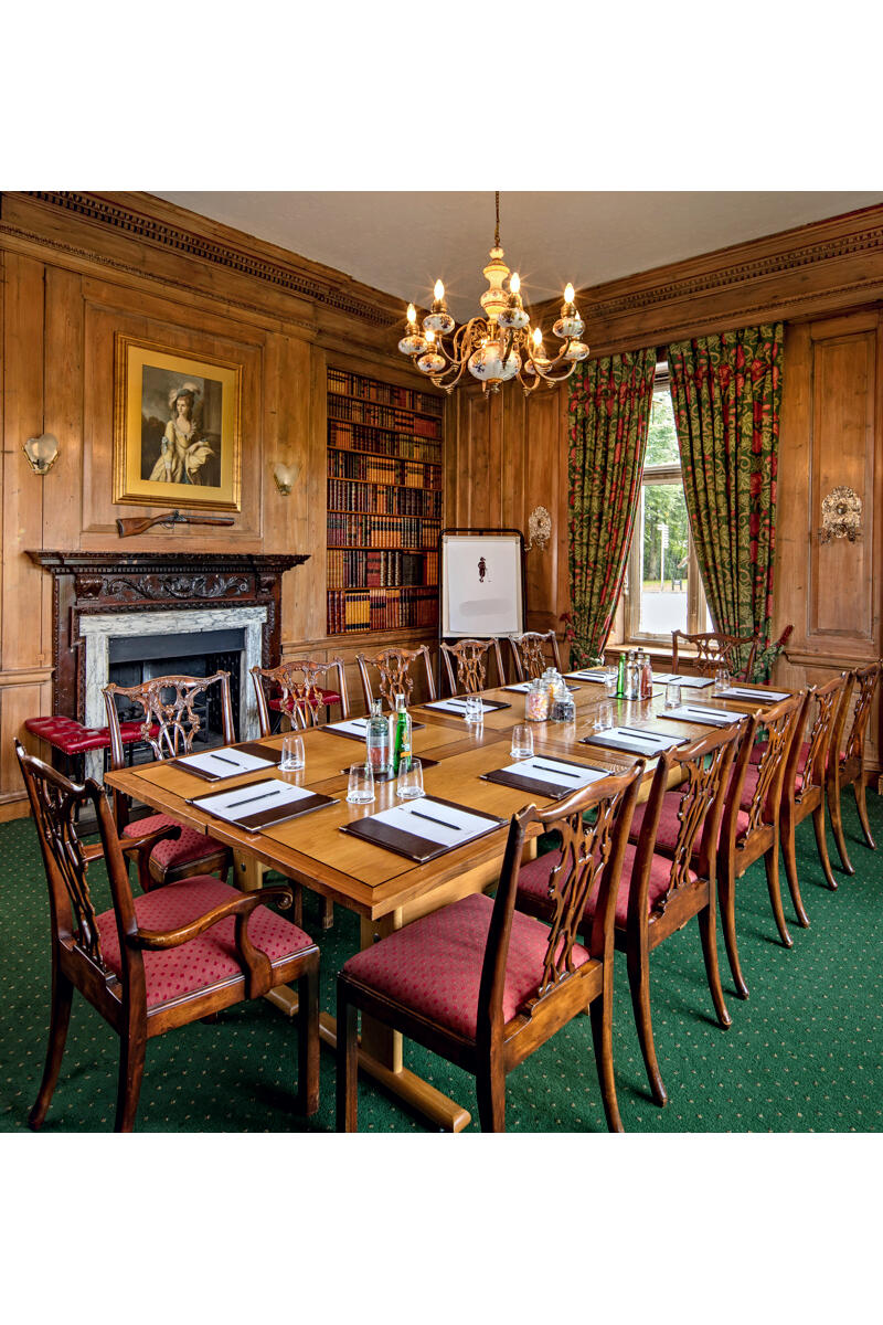Wood-panelled manor house boardroom with fireplace