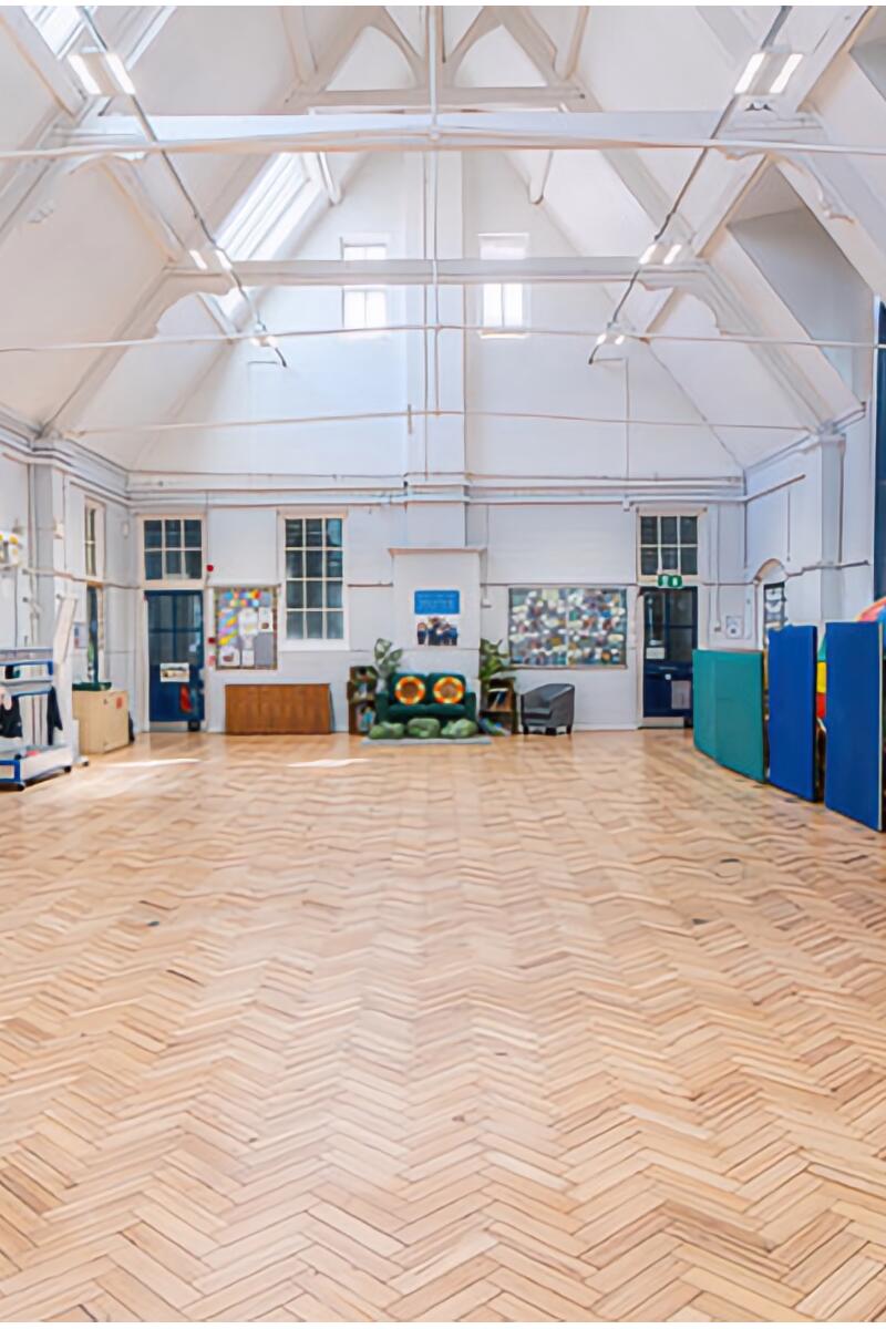 Victorian school hall with vaulted ceiling and parquet flooring