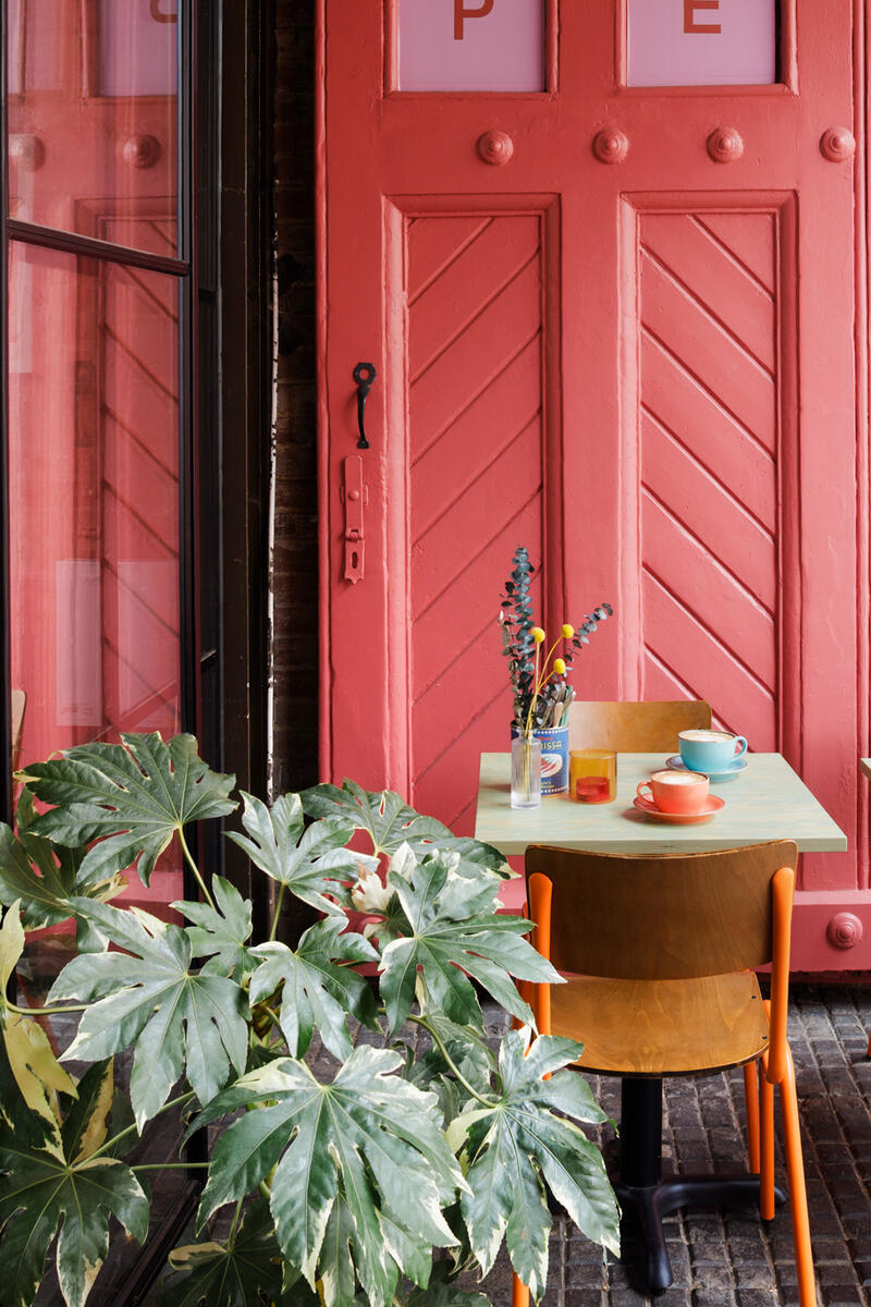 Film and photoshoot location featuring colourful café interiors with pink panelled doors, exposed brick and retro styling — available to hire