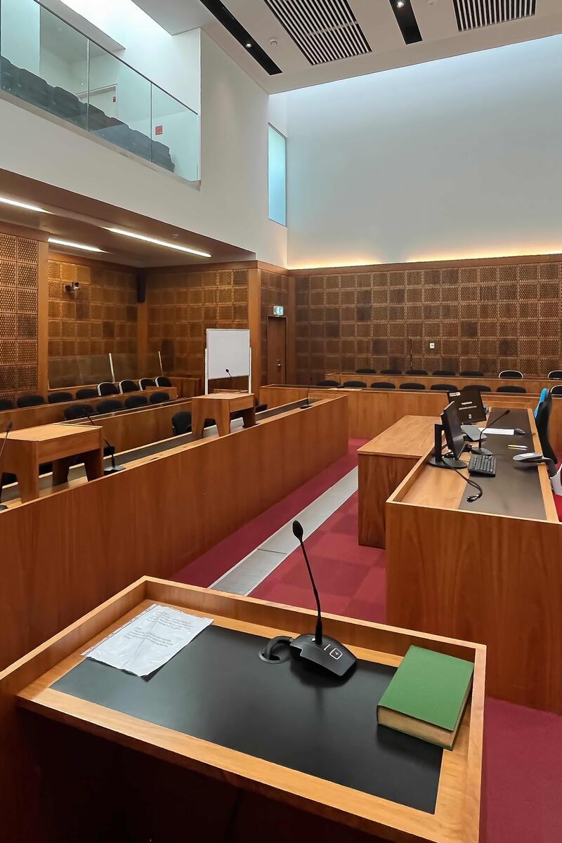 Mock Crown courtroom interior with judge’s bench, jury box, public gallery and modern wood-panelled design.