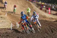 Motocross riders tackle tight jumps on track