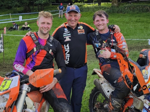 2 Enduro riders stand with the team manager at the end of a days racing