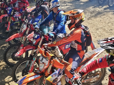 A group of enduro riders sat on their offroad bikes at the start line of the Wild Willys Hard Enduro race.