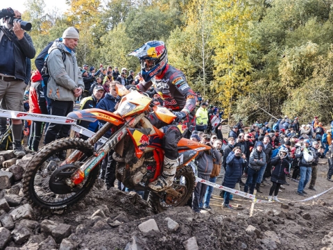 Enduro motorbike rider scrambling uphill at a race event with crowds watching on