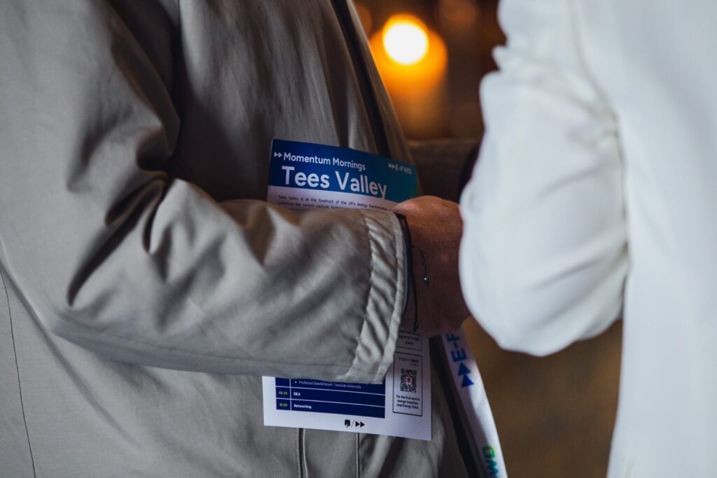 Close up of an arm holding a Momentum Morning Tees Valley flyer