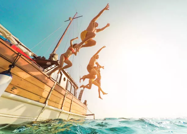 Group jumping off a boat into the sea during a Marbella stag boat party