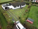 Luftfoto av enplansvilla med garage och trädgård inför takbyte