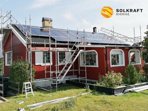 solceller på rött trähus