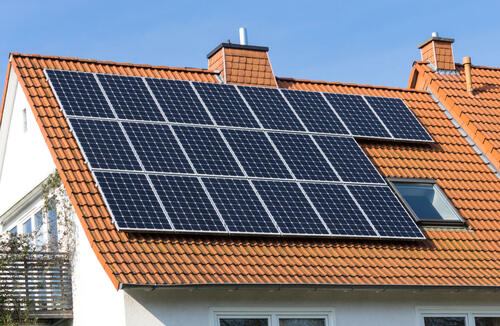 solcellsanläggning monterad på villa med rött tegeltak