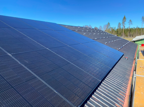 Svarta solpaneler mot blå himmel