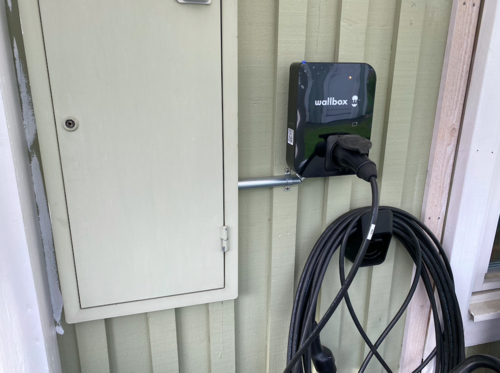 Laddbox med kabel monterad på husvägg