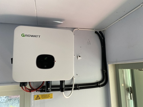 Vit växelriktare för solceller monterad på vägg inomhus