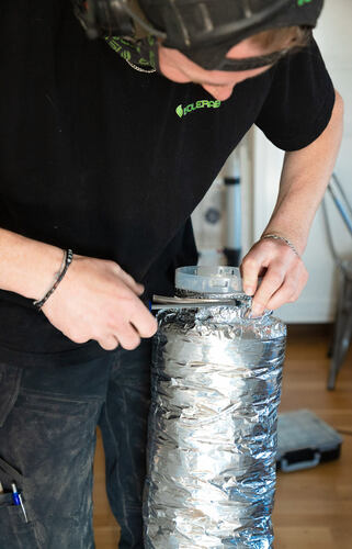 Isolerab-tekniker förbereder flexibelt ventilationsrör med isolering för montering