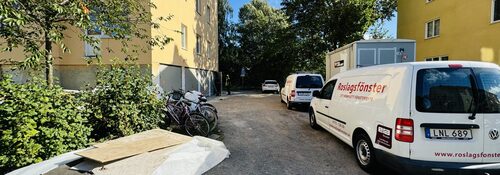 Roslagsfönster servicebil parkerad vid bostadshus under pågående arbete
