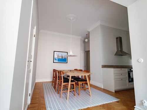Matplats och vitt kök i öppen planlösning med rostfri fläkt och matta, renoverat av Jobryan i Vasastan