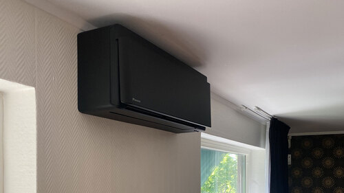 Svart väggmonterad Daikin luftvärmepump installerad i bostad
