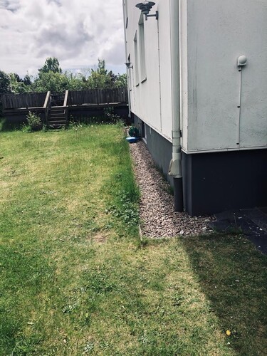 Färdigställd dränering med återfylld mark och grus längs villagrund i Halland